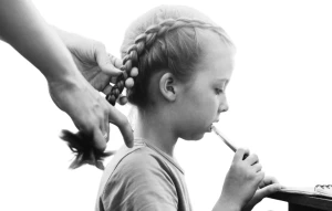 Дівчинці заплітають коси