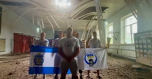 Тренер і команда у пошкодженому боксерському тренувальному залі в Херсоні. Скриншот з відео