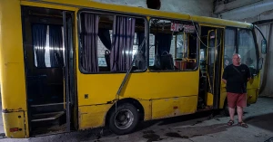 Олег Корнієнко поруч з автобусом, яким він керував, коли в нього влетів російський дрон. Фото: El Mundo
