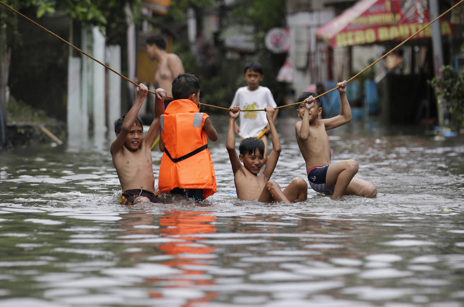 Хлопчики грають біля своїх затоплених будинків після сильних дощів від тропічного шторму "Nesat" в затопленій частині Маніли, Філіппіни, 27 липня 2017 року. (Photo by Aaron Favila / AP Photo)